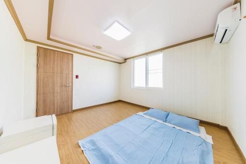 a room with a blue bed in the middle of it at Remember Youth Hostel in Gyeongju