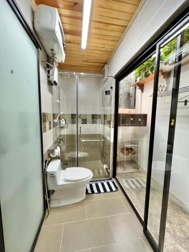 a bathroom with a shower and a toilet in it at Nhà An Cozy in Da Lat