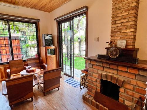 a living room with a brick fireplace and a table and chairs at Nhà An Cozy in Da Lat
