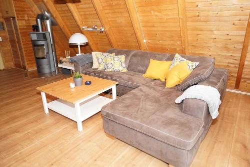 ein Wohnzimmer mit einem Sofa und einem Couchtisch in der Unterkunft Zeltdachhaus - strandnah - extra TV im Schlafzimmer in Damp