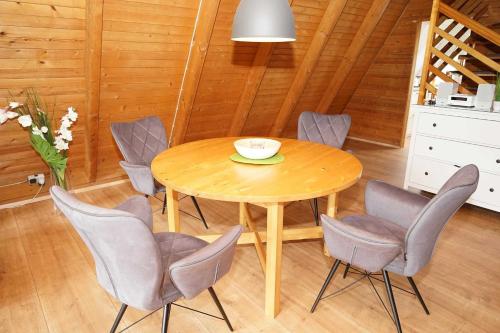 ein Esszimmer mit einem Holztisch und Stühlen in der Unterkunft Zeltdachhaus - strandnah - extra TV im Schlafzimmer in Damp