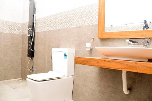 y baño con lavabo, aseo y espejo. en Kavin beach hotel en Hikkaduwa