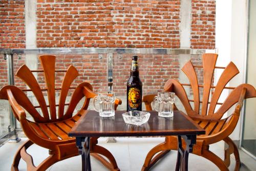 a table with a bottle of wine and two chairs at Kavin Beach Hotel Hikkaduwa in Hikkaduwa