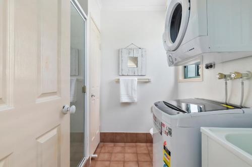 ein kleines Bad mit einem Waschbecken und einer Waschmaschine in der Unterkunft Terrapin Apartment 4 in Noosaville