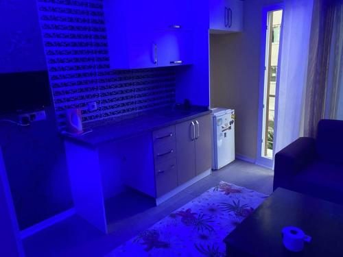 uma cozinha com iluminação azul numa sala de estar em İmperyum otel em Kaleköy