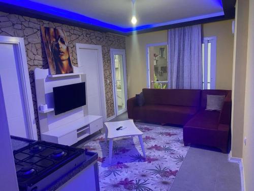 a living room with a couch and a tv at İmperyum otel in Kaleköy