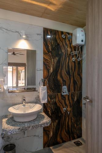 a bathroom with a sink and a wooden wall at HillRock Resort & Villas, Neral-Karjat in Karjat