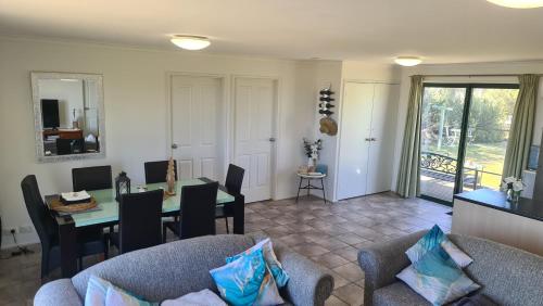 a living room with a table and chairs at Coorong Lakeside Cottage in Meningie