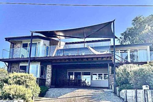 a large house with a wrap around porch and balcony at ELEGANT LUXURY, STUNNING SEA VIEWS-see whales pass in Avoca Beach