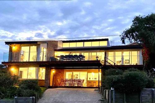 a large house with a lot of windows at ELEGANT LUXURY, STUNNING SEA VIEWS-see whales pass in Avoca Beach