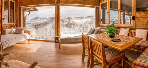 a living room with a table and a large window at Apartmani Lunija in Gornji Milanovac
