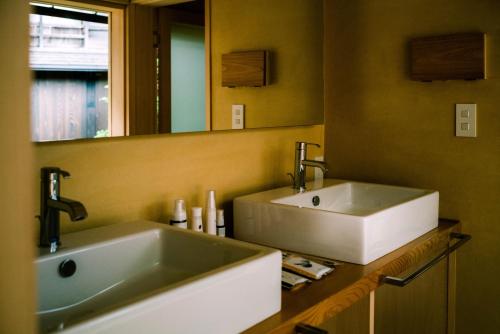 a bathroom with two sinks and a large mirror at TANIYA in Takayama