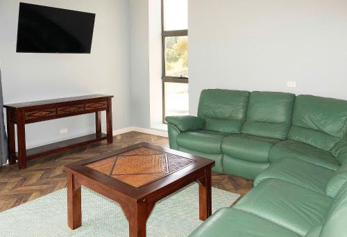 a living room with a green couch and a coffee table at Hatchers Richmond Manor in Richmond
