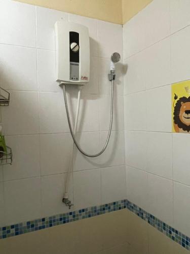 eine Dusche im Bad mit einem Schlauch an der Wand in der Unterkunft Mango House in Ko Lanta