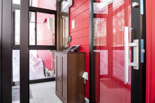 a bathroom with red walls and a red door at niseko / Vacation STAY 4376 in Niseko