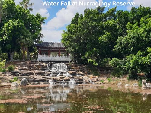 a temple in a park with a pond and a waterfall at Kaban Power 7 in Doonside