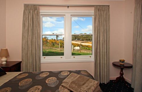 a bedroom with a window with a view of a field at Hill Cottage Hahndorf in Hahndorf