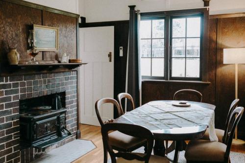 comedor con mesa y chimenea en The Brown House Tenterfield, en Tenterfield