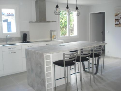 - une cuisine avec un grand comptoir en marbre et des tabourets dans l'établissement La plage à pied, à Bidart