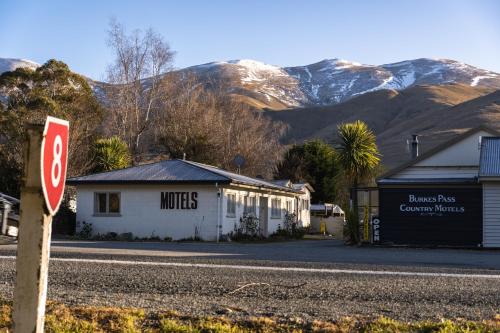 a stop sign on the side of a street with mountains at Burkes Pass Country Motels in Burkes Pass