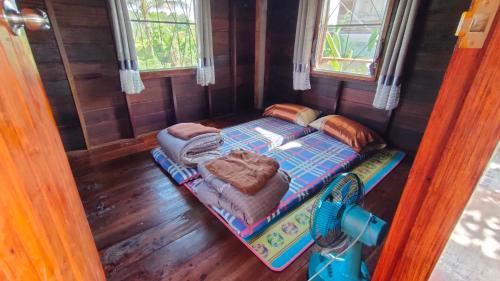 Habitación pequeña con cama y sofá en Na mong Homestay, en Nan