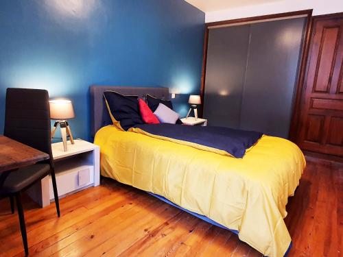 a bedroom with a bed with yellow sheets and pillows at La ruelle des 2 vallées in Arreau