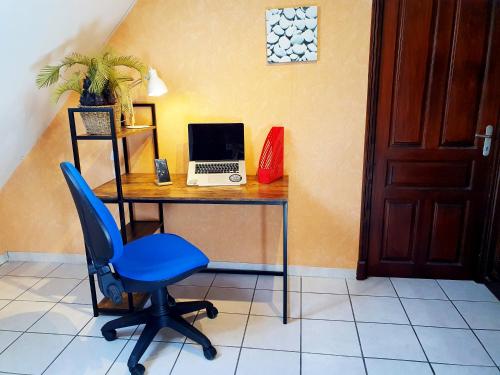 a desk with a laptop and a blue chair at La ruelle des 2 vallées in Arreau