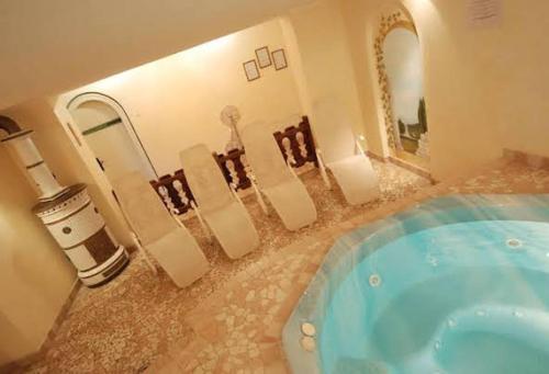 La salle de bains est pourvue d'une baignoire et d'un grand miroir. dans l'établissement Park Hotel Villa Trunka Lunka, à Cavalese