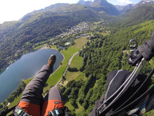 a person is flying a gondola over a lake at La ruelle des 2 vallées in Arreau
