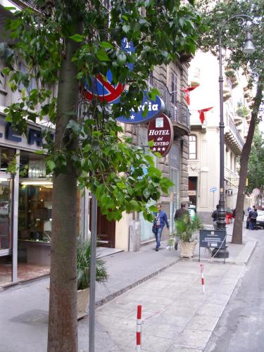 a street with a tree and a sign on a sidewalk at Hotel del Centro in Palermo