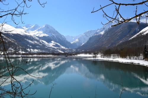 a view of a lake with snow covered mountains at La ruelle des 2 vallées in Arreau