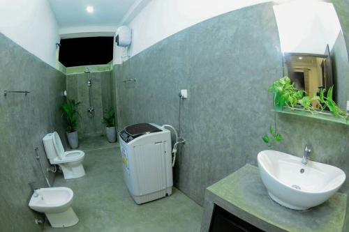 łazienka z 2 toaletami, umywalką i prysznicem w obiekcie THE SANCTUARY- Tangalle w Tangalli