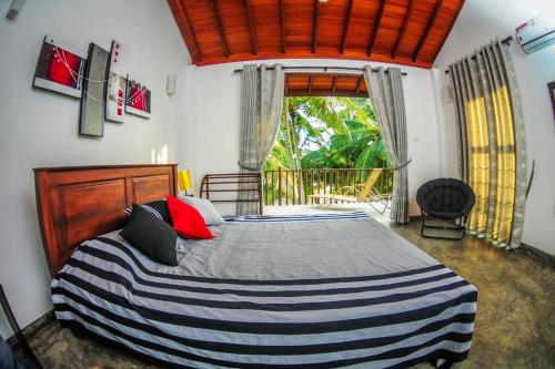 1 dormitorio con cama grande y ventana grande en THE SANCTUARY- Tangalle en Tangalle