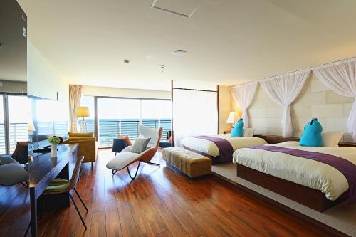 a hotel room with two beds and a desk at Sayan Terrace Hotel & Resort in Onjuku