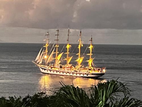 a tall ship sitting on the ocean at night at Vue Mer/3Beds/Piscine/wifi/900 mètres de la plage in Deshaies