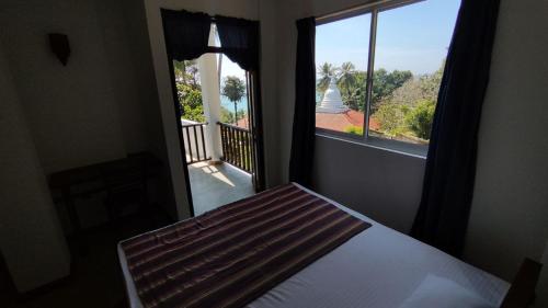 um quarto com uma cama e vista para uma varanda em Arazo villa em Unawatuna