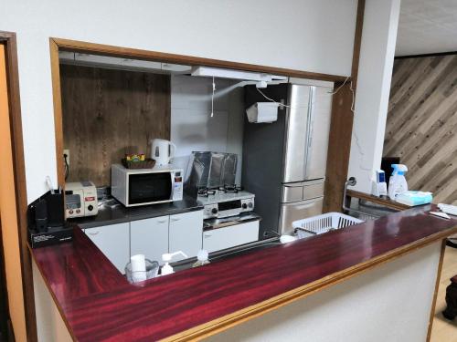 a kitchen with a counter top with a microwave at 暮らすように過ごす温泉宿　白老大使館 in Shiraoi