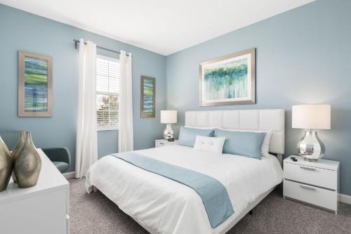 a blue bedroom with a large bed and a window at Champions Gate Resort, Game Room, Theater, Miles From Disney! in Davenport