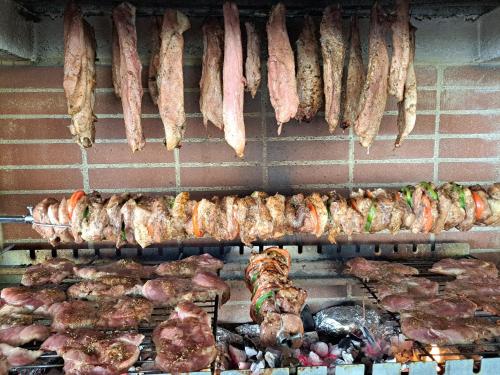 a bunch of meats and sausage hanging on a brick wall at Kazonis Studios in Kalymnos