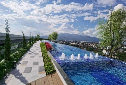 a swimming pool with a fountain in a city at Modern style room with sky pool 古城边天际泳池公寓 in Chiang Mai