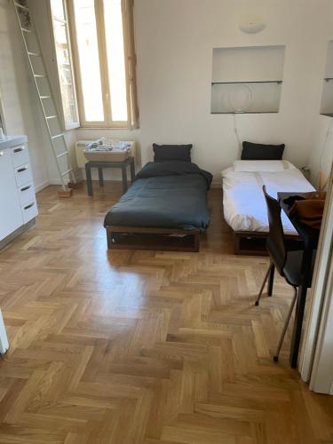 1 Schlafzimmer mit 2 Betten und Holzboden in der Unterkunft Ponte Milvio Smart Appartamento in Rom