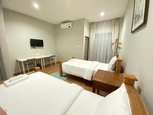 a hotel room with two beds and a desk at Alleyhill Phuket - Private & Cozy Boutique in Phuket Town