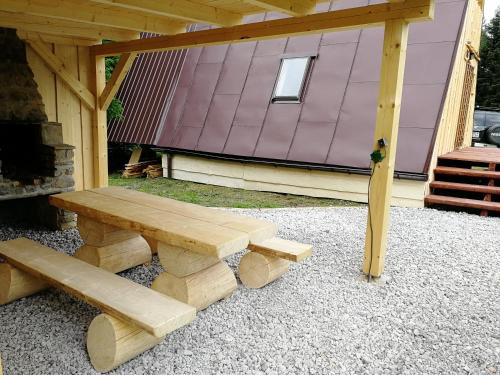 a wooden bench sitting in front of a building at Chata Zuzka pod Babou horou in Oravská Polhora