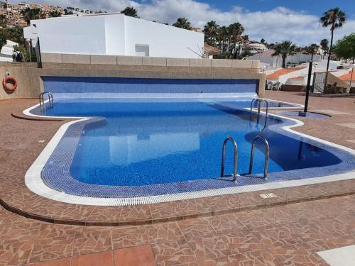 een groot zwembad met blauw water bij la Casetta Island village in Adeje