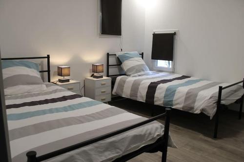 deux lits côte à côte dans une pièce dans l'établissement Logement indépendant très calme dans propriété, à Saint-Loubès