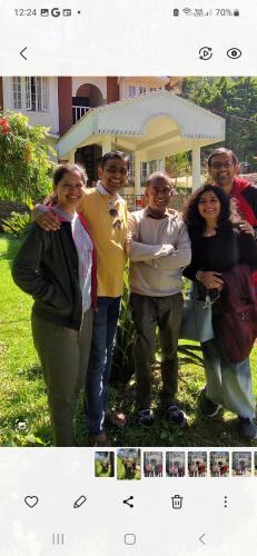 a group of people standing in front of a house at Narmada Holiday Home in Ooty