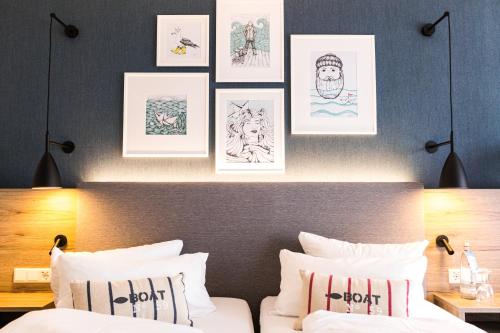 a bedroom with a bed with drawings on the wall at Hotel Wehrburg in Cuxhaven
