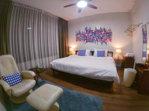 1 dormitorio con 1 cama grande y 1 silla en Baan Nai Soi Mini Hotel, en Chiang Mai