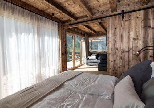 a bedroom with a bed in a room with wooden walls at Chalet Tschogerhof Tiers am Rosengarten Dolomiten in Tires