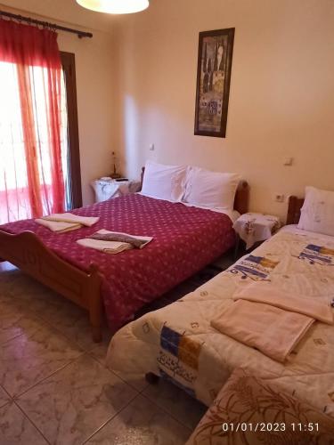 a bedroom with two beds and a window at ΡΑΧΗ in Kerasea